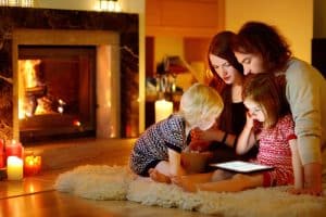 Energy efficient Furnace Installations in Calgary Alberta portrayed by family sitting on the floor in a warm home.